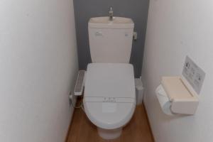 a bathroom with a toilet with a remote control next to it at Suncity Hakata in Hakata