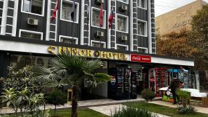 a woman standing in front of a building at Chinor Hotel Fergana in Fergana