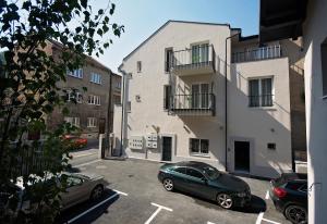 two cars parked in a parking lot in front of a building at Enjoy Apartments in Sarajevo