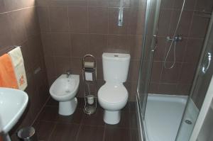 uma casa de banho com um WC, um chuveiro e um lavatório. em Casa Sul Moledo Beach em Moledo