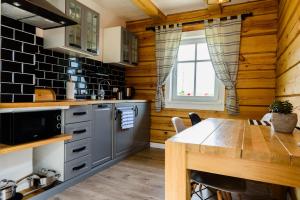 una cocina con paredes de madera y una mesa en una habitación en Apartamenty Szelągówka, en Sorkwity