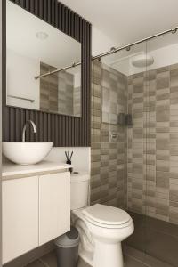 a bathroom with a white toilet and a sink at Casa G, en Rionegro in Rionegro