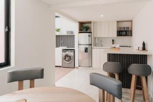 a kitchen with a refrigerator and two chairs in it at Casa G, en Rionegro in Rionegro