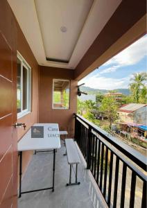 a balcony with a table and a bench and a view at Lia Clarke Transient House in Nasugbu