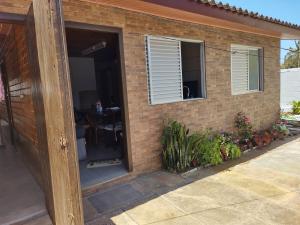 a brick house with a door and a window at House with pool Arroio do Sal in Arroio do Sal