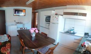 a kitchen with a wooden table with flowers on it at House with pool Arroio do Sal in Arroio do Sal