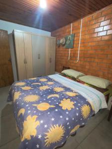 a bedroom with a blue comforter on a bed at House with pool Arroio do Sal in Arroio do Sal +20 photos