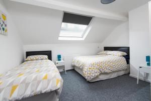 Duas camas num quarto com paredes brancas em Big Fish - Charles St South em Belfast