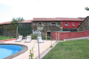 a patio with chairs and a swimming pool in a yard at Aldea Rural A Cortiña in Pepín