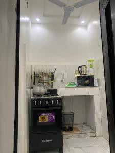 a small kitchen with a stove and a counter at Deux chambres salon in Adjarra