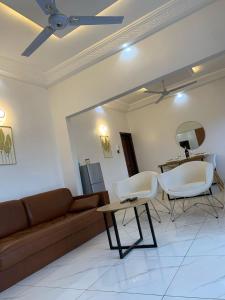 a living room with a couch and chairs and a table at Deux chambres salon in Adjarra +18 photos