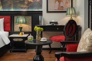 a hotel room with a bed and a chair and a piano at Royal Hotel Vinh Yen in Nhân Mỹ