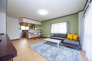 a living room with a couch and a table at WAKE Inn 府中 in Fuchu