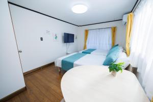 a hotel room with two beds and a table at WAKE Inn 府中 in Fuchu