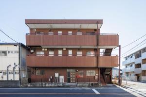 a tall brown building with a lot of windows at WAKE Inn 府中 in Fuchu