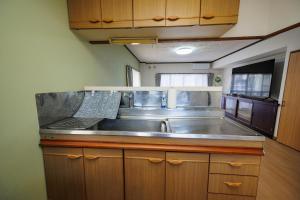 a kitchen with a stainless steel sink in a trailer at WAKE Inn 府中 in Fuchu +33 photos