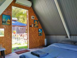 an attic bedroom with a bed and a window at Western View Chiangdao Camping in Chiang Dao