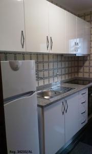 a kitchen with white cabinets and a sink at Douro & Sea - River Side in Vila Nova de Gaia