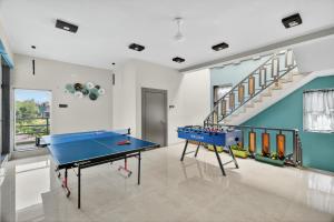 a room with a ping pong table and a staircase at Meraki Hillside Villa in Panchgani
