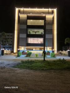 a large building with lights in front of it at night at Hotel Smart City Park Inn in Tada