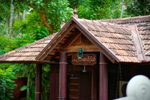 a building with a sign on top of it at Periyaveettil Heritage in Neyyāttinkara