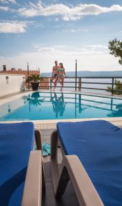two people sitting in the swimming pool at a resort at Villa Marina in Omiš