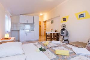 een woonkamer met een bed en een keuken bij Apartments Juras in Brzac