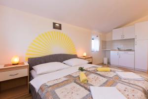 een slaapkamer met een groot bed en een gele ventilator. bij Apartments Juras in Brzac