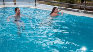 a man and woman swimming in a swimming pool at Villa Marina in Omiš