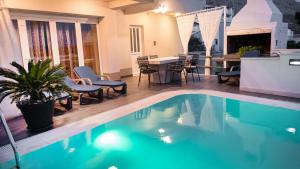 a swimming pool with chairs and a table and a dining room at Villa Marina in Omiš