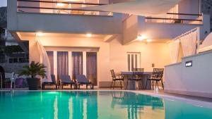 a house with a swimming pool with a table and chairs at Villa Marina in Omiš