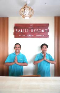 two men standing in a room praying with their hands in front at Salili Resort in Gili Islands