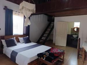 a bedroom with a large bed and a staircase at Ambositra Lodge in Ambositra +8 photos