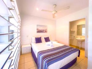 a small bedroom with a bed and a sink at Tropic Haven in Airlie Beach