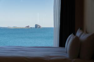 ein Schlafzimmer mit Fenster zum Meer in der Unterkunft Hygge Hotel in Seogwipo