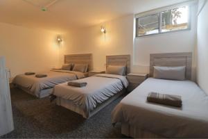 a room with three beds and a window at The Castle Star in Amman
