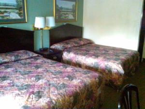 Habitación de hotel con 2 camas y 2 lámparas en Knights Inn - Battle Creek, en Battle Creek