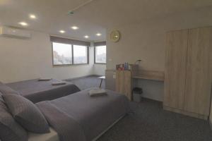 a bedroom with two beds and a clock on the wall at The Castle Star in Amman