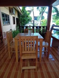 a wooden table and chairs on a patio at บ้านพักแอบสบาย abbsabyehome in Klong Wan
