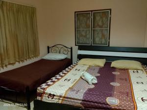 two beds sitting in a room with at บ้านพักแอบสบาย abbsabyehome in Klong Wan