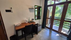 a home office with a wooden desk and a window at Mothership in Tangalle +70 photos