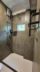 a bathroom with a shower with a window at Mothership in Tangalle