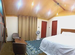 a bedroom with a bed and a desk and a fan at The Crescent Resort in Skardu