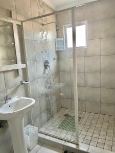 a bathroom with a shower and a sink at Lyn's Self Catering in Swakopmund +34 photos