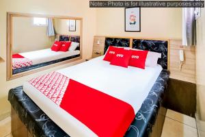 two beds with red pillows in a room at OYO Hotel Itarantim, São Paulo in São Paulo