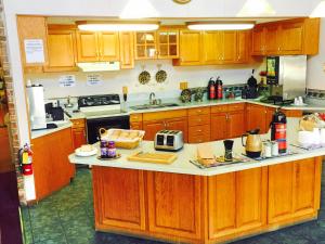 a kitchen with wooden cabinets and a counter top at HOTEL DEL SOL - Pensacola in Pensacola