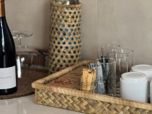 a wooden tray with glasses and a bottle of wine at Villa Océan Gravier Rodrigues in Mt Bois Noir