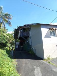 a house with a garage with a balcony at Ti caze memé étage in Saint-Philippe