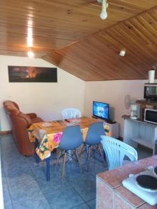 a dining room with a table and chairs and a couch at Ti caze memé étage in Saint-Philippe