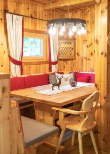 a dining room with a wooden table and a chair at Almhütte Tamberger in der Feldpann-Alm in Rauth